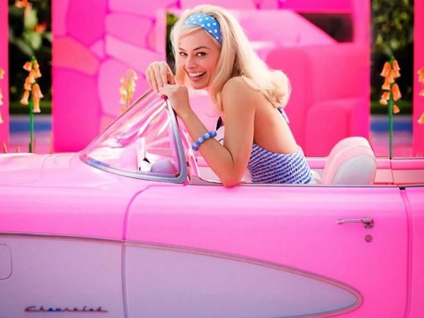 Margot Robbie als Barbie in einem pinken Cadillac