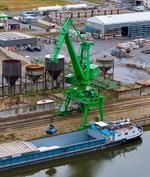 Luftbild auf die Hafenanlage mit einen Krank und einem beladenen Schiff.