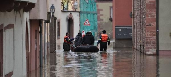 Die überflitete Wertheimer Altstadt. Im Hintergrund sind vier Männer mit einem Hochwasserrettungsboot zu sehen. 