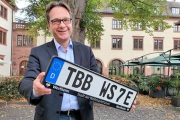 Jürgen Strahlheim präsentiert im Hof des Rathauses den neuen Kfz-Kennzeichenhalter "Stadt der Weltmarktführer"