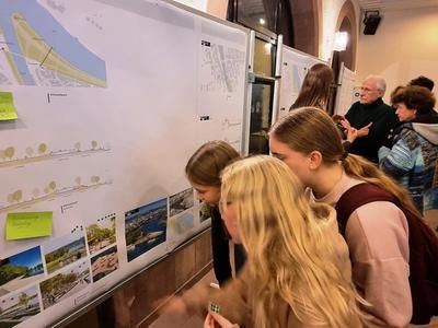 Jugendliche aus Wertheim schauen sich interessiert die Pläne zum "Begegnung und Leben am Wasser" an. 