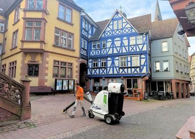 Ein Mitarbeiter reinigt den Platz vor dem Grafschaftsmuseum