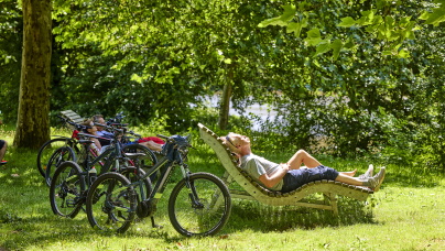 Fahrradfahrer entspannen im Grünen auf einer Himmelsliege