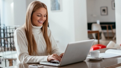 Frau Sitzt am Laptop und lächelt