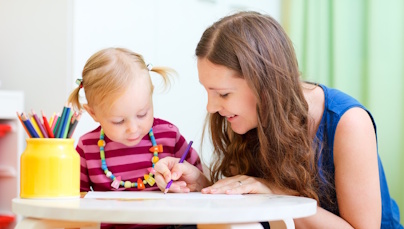 Frau und Kind beim Malen am Tisch
