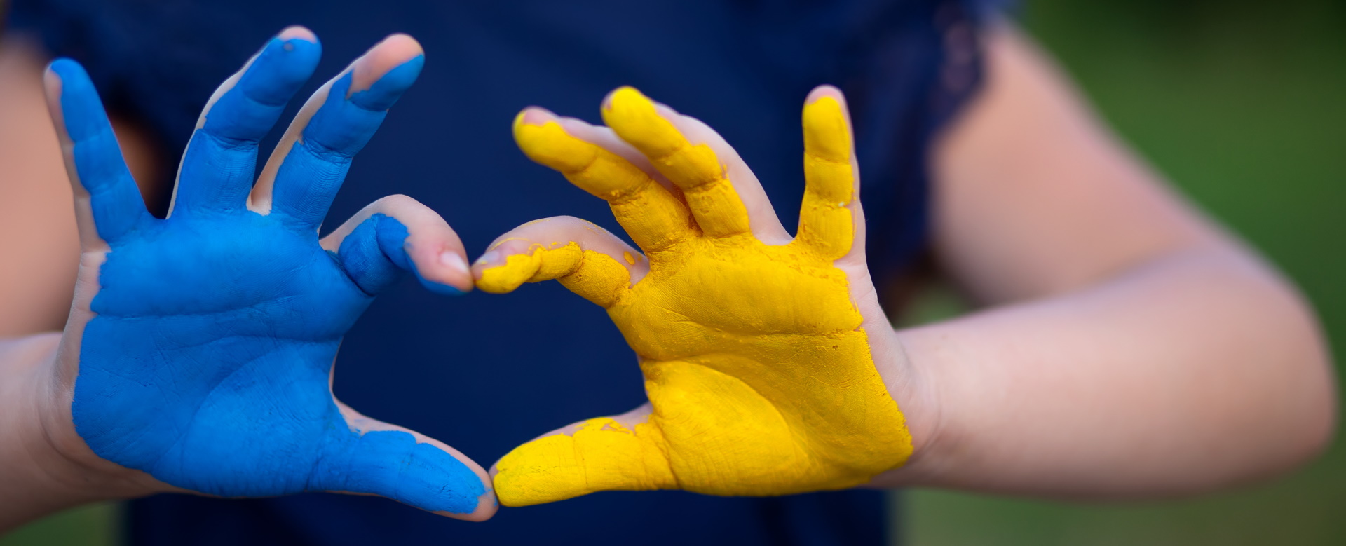 Symbolbild Hilfe für die Ukraine. Zwei Hände, die blau und gelb angemalt sind, formen ein Herz.